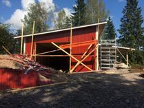 Punainen puinen autotalli rakentuu